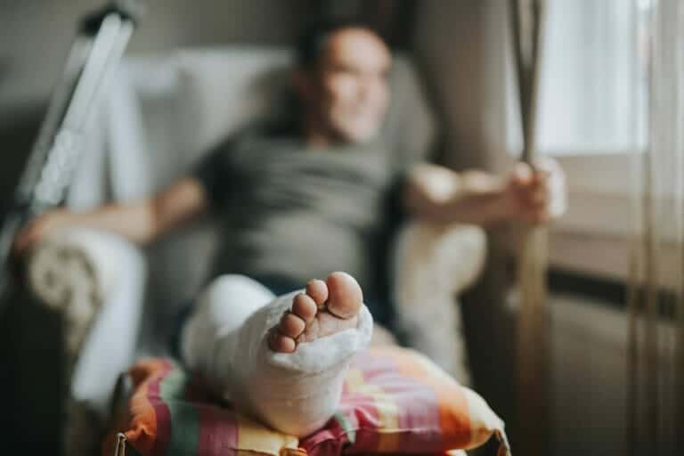 Man with broken leg at home concept for personal injury compensation.