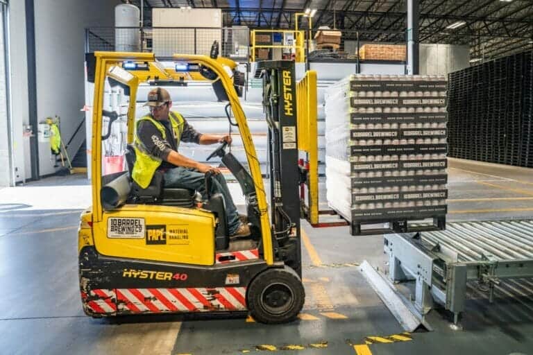 Person safely backing up a forklift at work to avoid any of the most common machine related injuries.