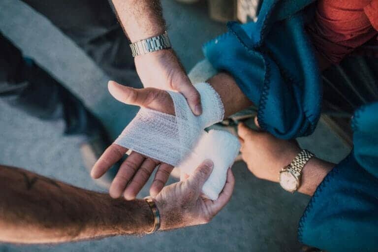 A person having their hand wrapped after a minor injury on the jobsite that may be reported for workers' compensation.