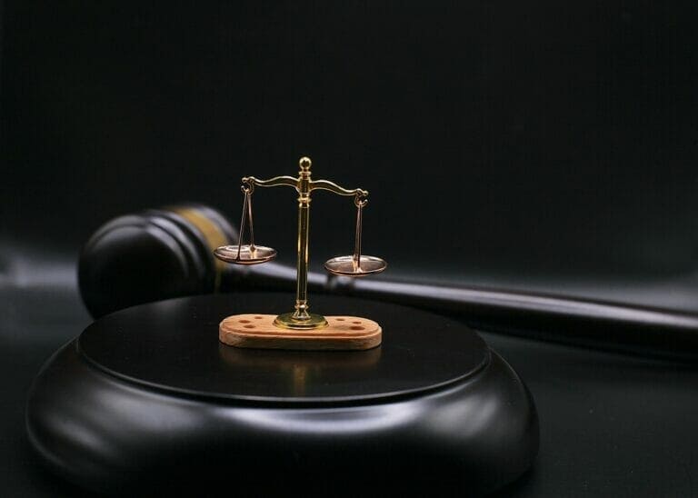 A gavel with the scales of justice on top of it during a slip and fall case examining contributory negligence.