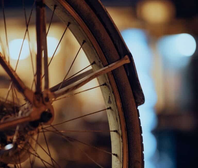 A close up of a bicycle tire after an accident with a car.