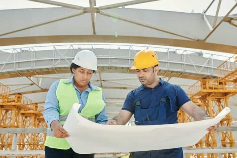 Two construction workers looking at plans for a project at work