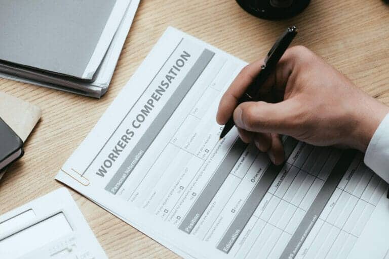 cropped view of man filling in Workers Compensation Accident Injury form