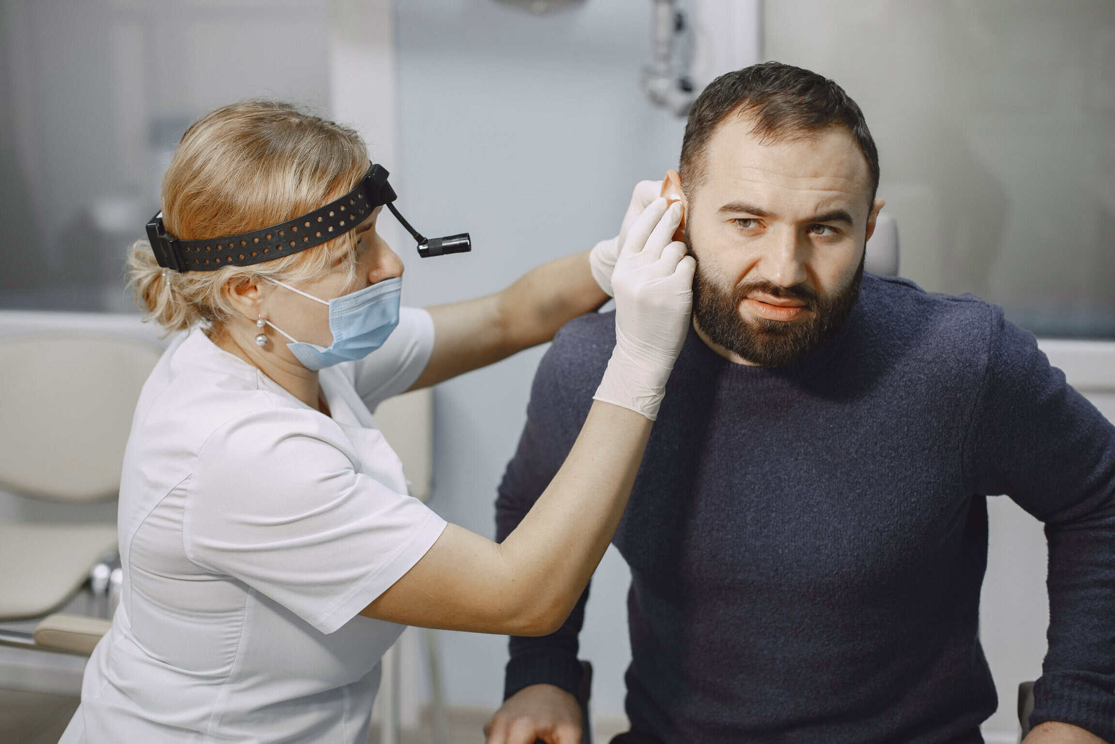 Man patient in the medical office. Doctor in medical mask.
