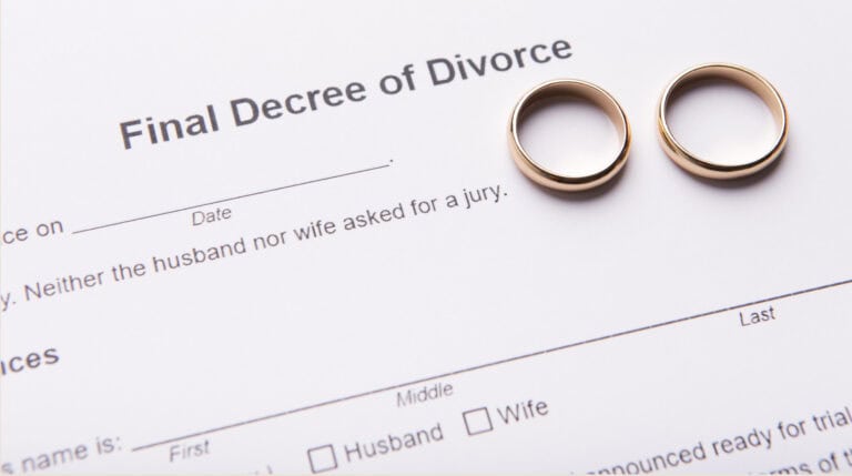 Two wedding rings placed on top of a final decree of divorce form.