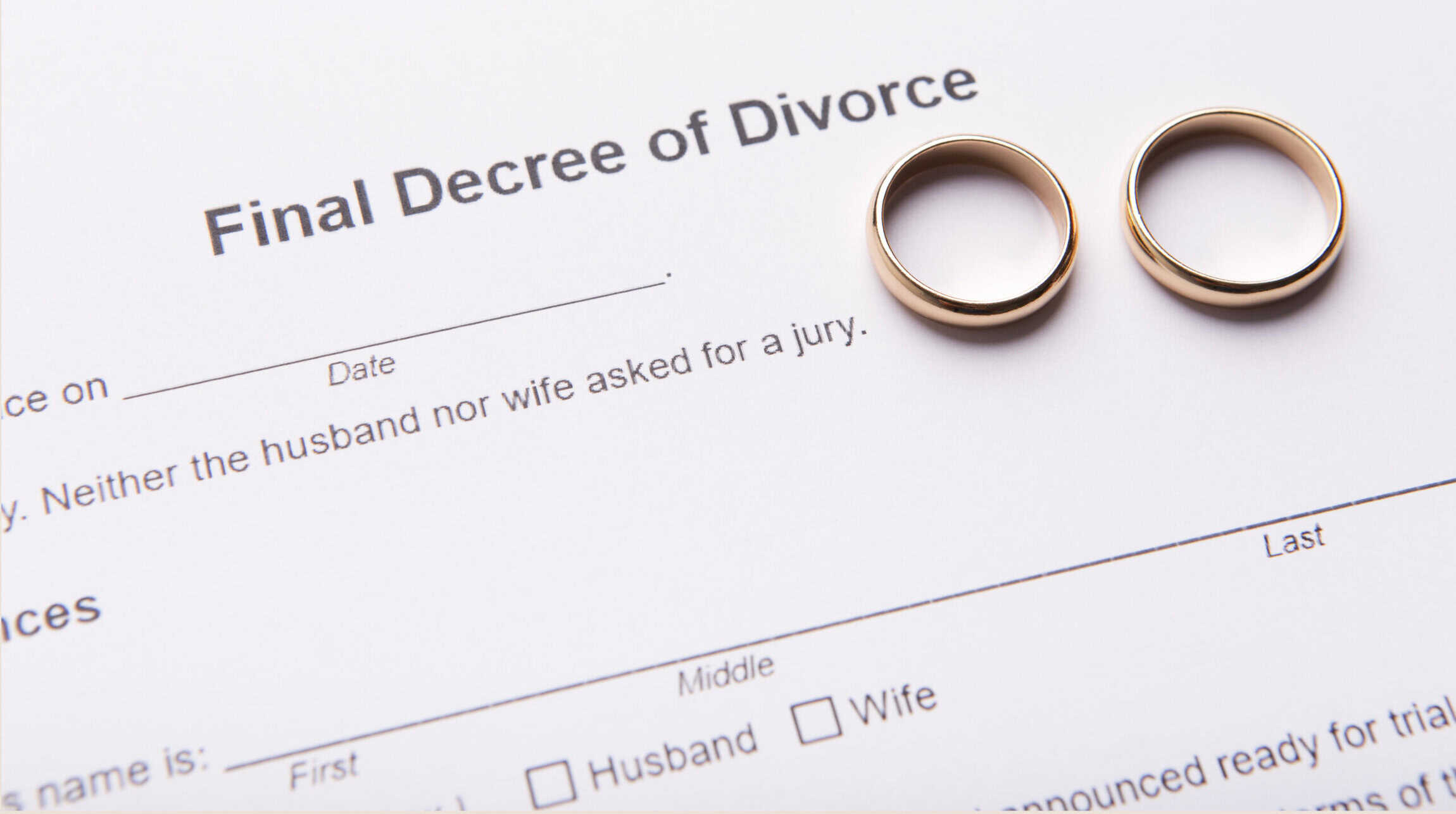 Two wedding rings placed on top of a final decree of divorce form.