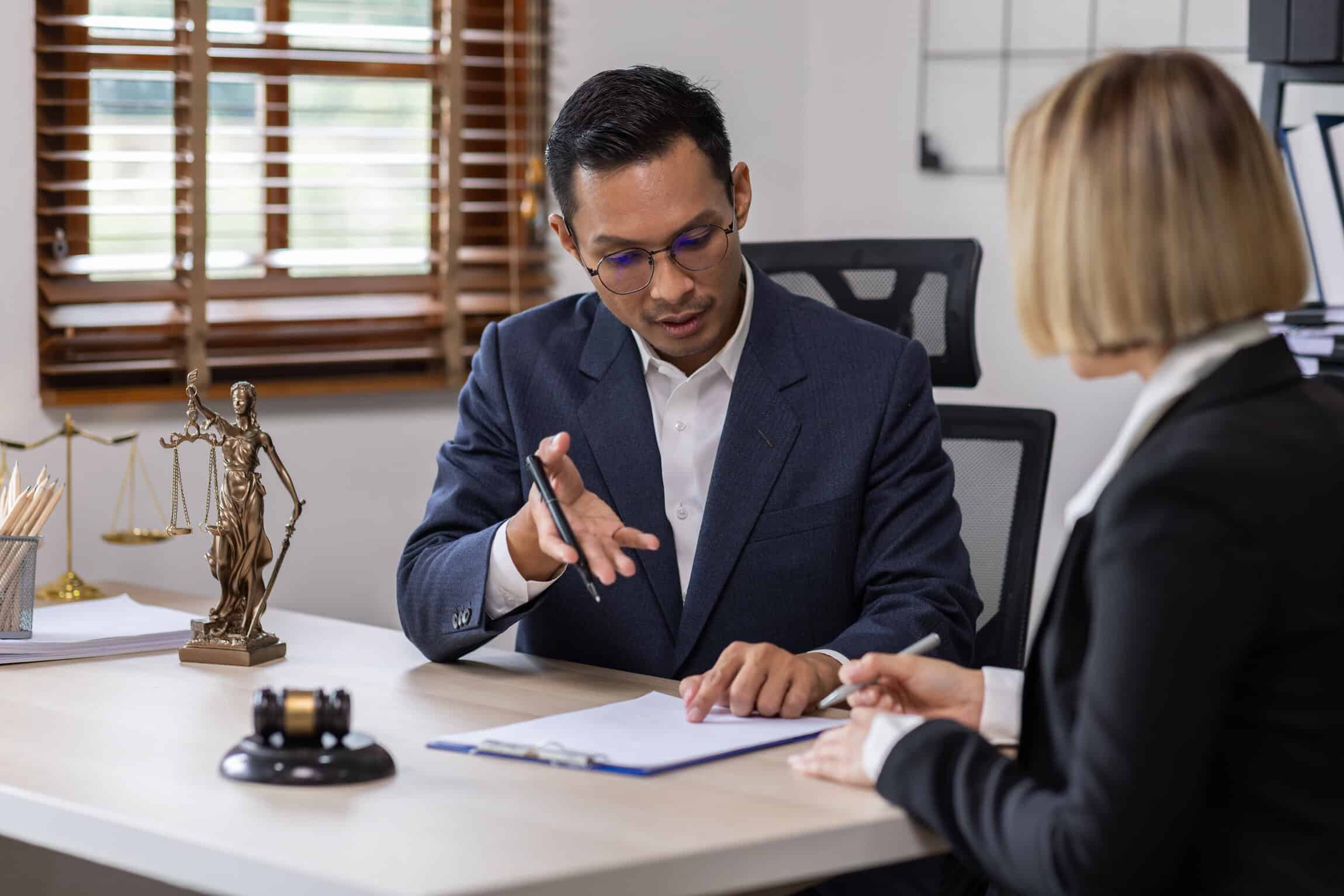 Personal injury attorney reviewing settlement paperwork with a client during a legal consultation